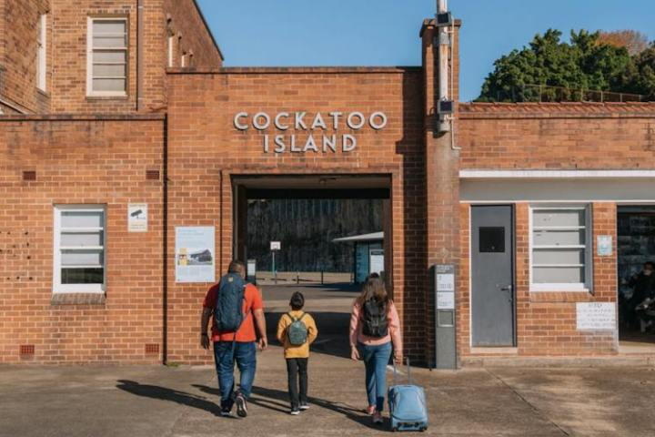 a group of people walking in front of a brick building