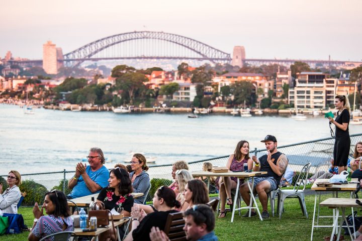 a group of people sitting next to a fence