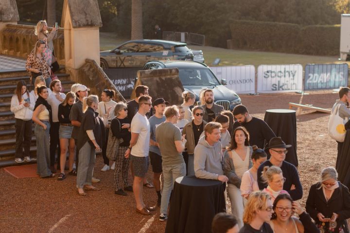 a group of people standing in front of a crowd posing for the camera