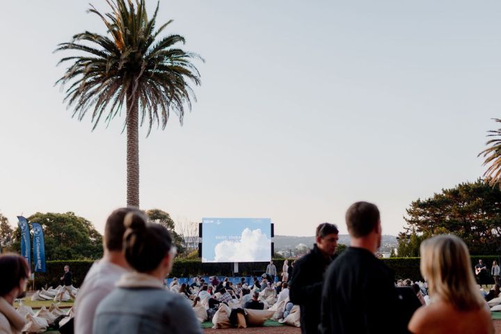 a group of people standing in front of a palm tree